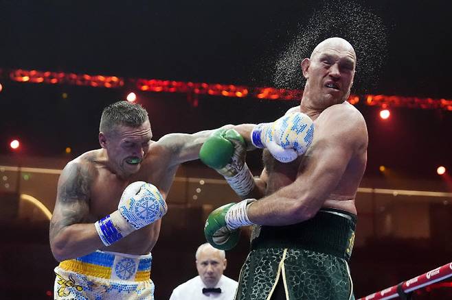 우크라이나의 헤비급 챔피언 올렉산드르 우식(왼쪽)이 타이슨 퓨리의 얼굴에 강펀치를 적중시키고 있다. 사진=AP PHOTO