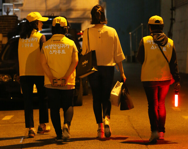 서울 동대문구 회기동 ‘안심귀가스카우트\' 대원들이 늦은 저녁 집으로 향하는 여성과 함께 가고 있다. 연합뉴스