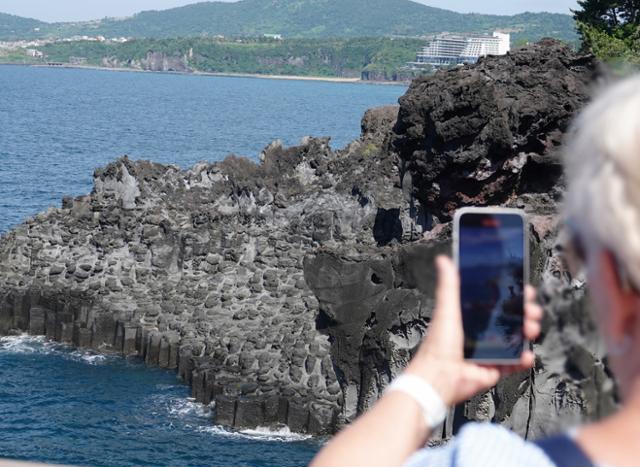 18일 오전 제주 서귀포시 중문관광단지에서 외국인 관광객이 대포주상절리대 사진을 찍고 있다. 천연기념물 443호인 대포 주상절리대는 두꺼운 용암이 빠르게 식는 과정에서 형성된 육각형 모양의 현무암 지대다. 제주=뉴시스