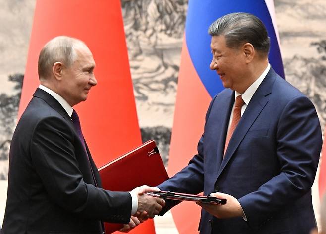 시진핑 중국 국가주석(오른쪽)과 블라디미르 푸틴 러시아 대통령이 16일 베이징 댜오위타이 국빈관에서 악수를 하고 있다./AP연합뉴스