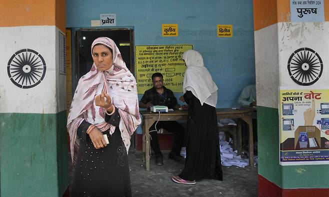 지난 13일(현지시간) 인도 동부 비하르주의 한 투표소에서 무슬림 여성이 투표를 마치고 나오고 있다. AP연합뉴스