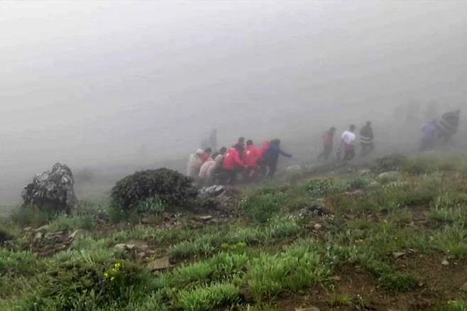 에브라힘 라이시 이란 대통령이 탑승한 헬리콥터가 악천후로 이란 북서부 산악 지역에 추락한 가운데 20일(현지시간) 사고 현장에서 구조대원들이 시신을 나르고 있다. (사진=AFP)