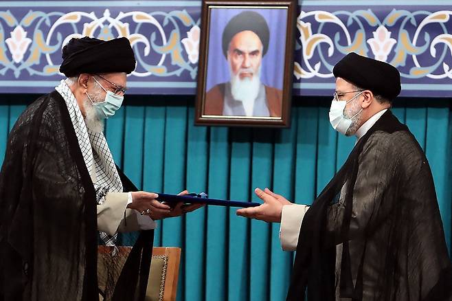 이란 최고지도자 아야톨라 알리 하메네이(왼쪽)이 에브라힘 라이시(오른쪽) 대통령 취임식에서 만난 모습. / AFP 연합뉴스