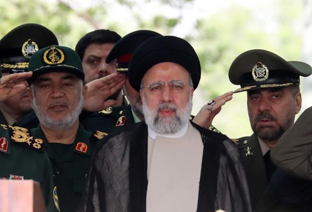 에브라힘 라이시(가운데) 이란 대통령이 지난달 17일 이란 테헤란에 있는 한 군사 기지에서 군인들의 경례를 받고 있다. 최고지도자 아야톨라 알리 하메네이의 뒤를 잇는 이란의 2인자였던 라이시 대통령은 19일 헬기 추락 사고로 사망했다. 테헤란=EPA 연합뉴스