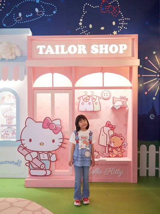 최애 캐릭터가 헬로키티라서 헬로키티 옷을 입고 온 김하윤 학생기자가 헬로키티 포토존에서 포즈를 취하고 있다.