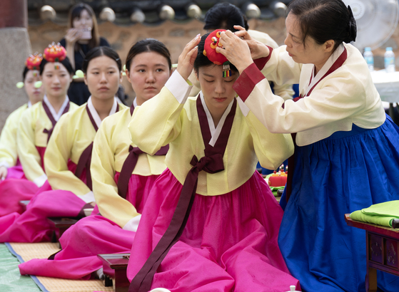 Women participate in an event celebrating Coming of Age Day on Monday at a Confucian academy in Busan. [YONHAP]