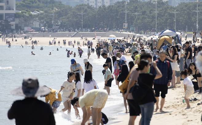 맑은 초여름 날씨를 보인 19일 오후 부산 해운대구 해운대해수욕장을 찾은 시민들이 더위를 식히고 있다. [연합]