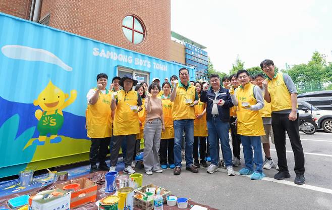 정영광 에쓰오일 부문장(앞줄 가운데)이 지난 18일 서울 마포구 아동생활시설 삼동보이스타운에서 열린 벽화 그리기 자원봉사활동 중 참석자들과 함께 기념사진을 촬영하고 있다. 에쓰오일 제공