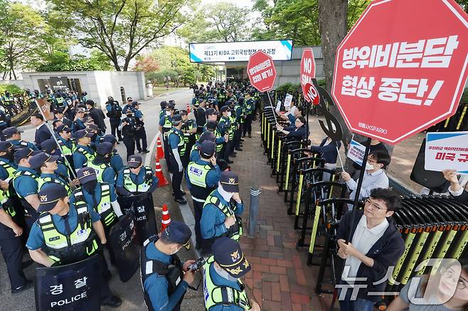 평화와통일을여는사람들(평통사)와 겨레하나 등 시민단체 관계자들이 21일 오전 서울 동대문구 한국국방연구원 앞에서 제12차 한미 방위비분담금특별협정(SMA) 체결을 위한 2차 회의 중단을 촉구하며 구호를 외치고 있다. 2024.5.21/뉴스1 ⓒ News1 민경석 기자