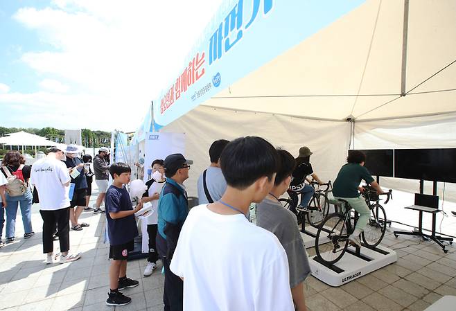 올림픽공원 평화의 광장에서 열린 ‘제1회 청소년 도박 문제 예방 주간 행사’에서 참가자들이 ‘자전거 가상주행’을 체험하고 있다.