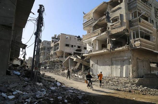 팔레스타인 가자지구 북부 자발리아 난민촌 주민들이 부서진 건물 사이를 지나가고 있다. 이곳 무장 정파 하마스와 이스라엘군의 전쟁으로 2만3000여명의 팔레스타인 주민들이 숨졌다.[신화연합뉴스]
