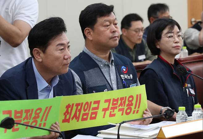 지난해 6월 22일 정부세종청사에서 열린 제7차 최저임금위원회 전원회의에서 류기정 한국경영자총협회 전무를 비롯한 사용자위원들이 최저임금 구분적용 필요성을 강조하는 손 팻말을 들어 보이고 있다. /조선DB