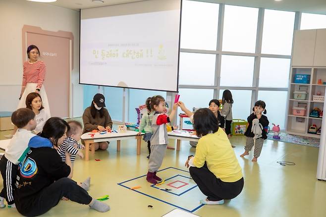 대구 서구의 한 공동육아나눔터에서 교육 프로그램에 참여한 학부모와 아이들이 민들레씨 만들기 놀이를 하고 있다. 서구 제공