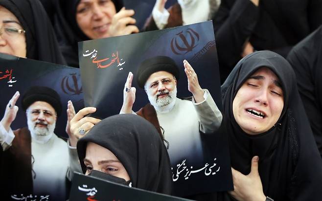20일(현지시간) 이란 수도 테헤란에서 추모 집회에 참석한 시민들이 전날 사망한 세예드 에브라힘 라이시 이란 대통령의 포스터를 들고 있다. EPA연합뉴스