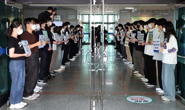 21일 부산대 대학본부 로비에서 의대 교수진과 학생들이 학칙 개정안 부결을 촉구하는 성명서를 발표하고 시위를 벌이고 있다. 뉴시스