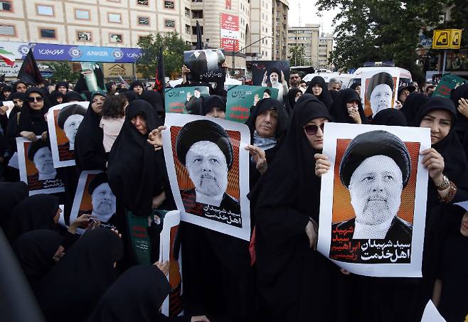 헬기 추락 사고로 숨진 에브라힘 라이시 이란 대통령 애도식이 열린 테헤란에서 여성들이 라이시 대통령의 포스터를 들고 있다. 연합뉴스