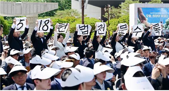 18일 오전 광주 북구 운정동 국립 5·18민주묘지에서 열린 제44주년 기념식에서 윤석열 대통령이 기념사를 하는 도중 광주시의회 5·18특위 소속 시의원들이 '5·18 헌법수록' 글씨가 적힌 손팻말을 펼쳐 보이고 있다. ⓒ연합뉴스