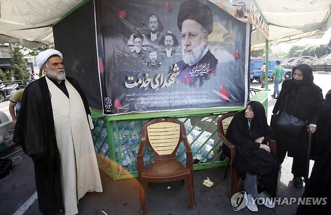 20일(현지시가) 이란 수도 테헤란에서 에브라힘 라이시 대통령의 초상화를 놓고 추도하는 시민들 [EPA=연합뉴스 자료사진. 재판매 및 DB 금지]