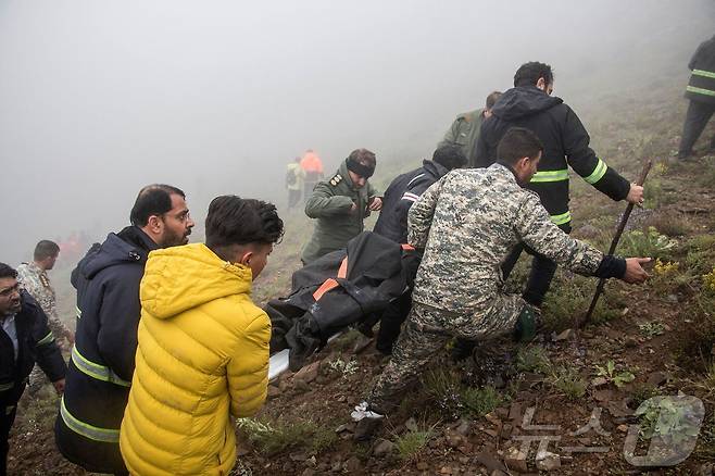 20일(현지시간) 에브라힘 라이시 이란 대통령을 태운 헬기가 추락한 바르자간 산악 지역에서 구조대원들이 시신을 옮기고 있다. 2024.05.21 ⓒ AFP=뉴스1 ⓒ News1 우동명 기자