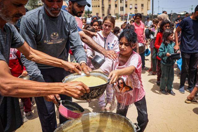 팔레스타인 피란민 어린이들이 19일 가자지구 최남단 도시인 라파에서 구호 식량을 배급받고 있다. 라파=AFP 연합뉴스