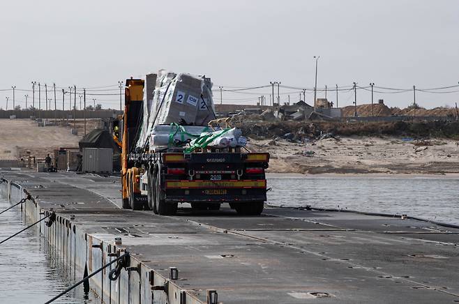 구호물품을 실은 트럭이 지난 19일(현지시간) 가자지구 인근 해안에 설치된 임시부두를 따라 이동하고 있다./로이터=뉴스1