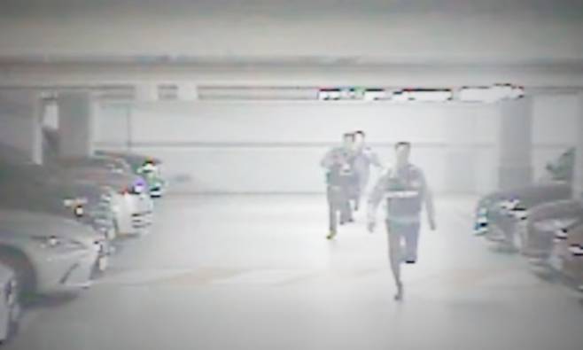 주차장 자동차 전화번호를 수집하던 남성이 도주하자 출동한 경찰관들이 쫓고 있다. 경찰청 제공