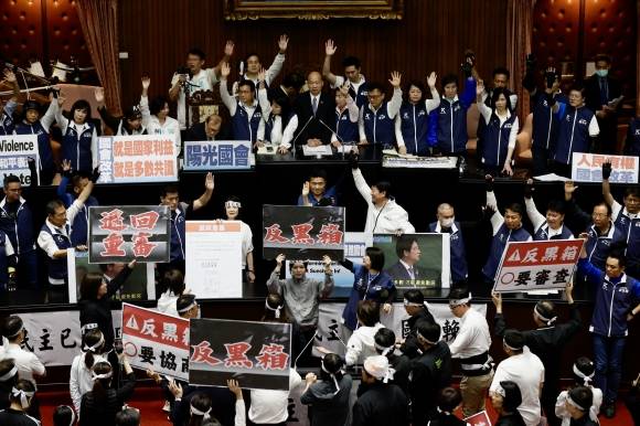 의회개혁법 충돌… 대만 의회 연일 육탄전 - 21일 대만 입법원(의회) 본회의장 연단 주변에서 여당인 민주진보당 의원들이 ‘5대 의회 개혁법’에 반대하는 피켓을 들고 있다. 과반 의석을 점유한 국민당과 민중당이 의회 권한 강화를 골자로 한 의회 개혁법 통과를 강행하면서 의회에선 연일 육탄전이 벌어지고 있다. 여소야대 국면에서 취임한 라이칭더 총통은 임기 초부터 난관을 맞닥뜨렸다. 타이베이 EPA 연합뉴스