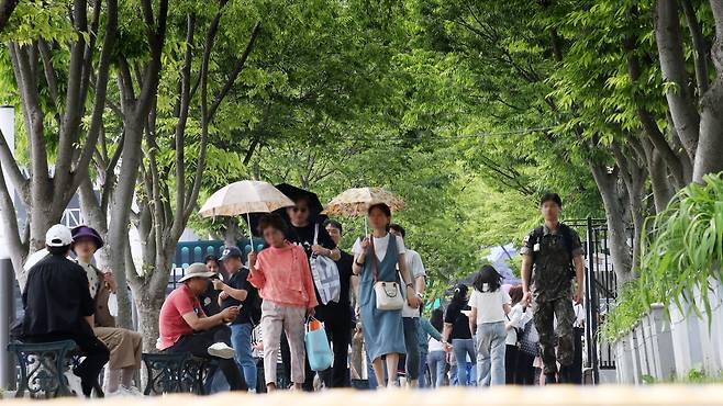 22일 오후 충남 천안 독립기념관을 찾은 관람객들이 더위를 피해 나무그늘 아래에 앉아 휴식을 취하거나 걷고 있다./신현종 기자