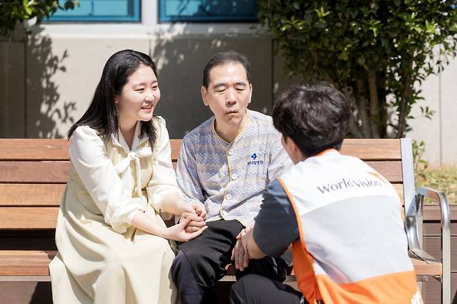 8일 경남 창원의 한 요양병원에서 직장인 김율 씨(왼쪽)가 아버지를 만나 월드비전 직원과 함께 이야기를 나누고 있다. 월드비전 제공