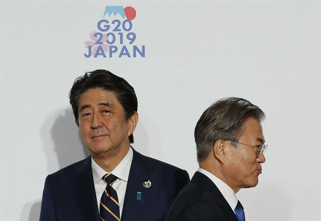 문재인 대통령이 2019년 6월 오사카에서 열린 G20(주요 20개국) 정상회의 환영식에서 아베 신조 일본 총리와 7초간 악수를 나눈 뒤 지나가고 있다. 오사카=AP 연합뉴스