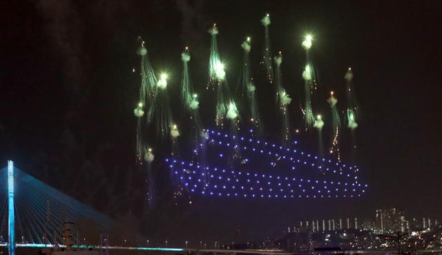 부산항 국제여객터미널 야외주차장에서 2021년 6월 열린 제14회 부산항축제에서 LED 불빛으로 배를 연출한 드론과 축포가 밤하늘을 수놓고 있는 모습. 연합뉴스