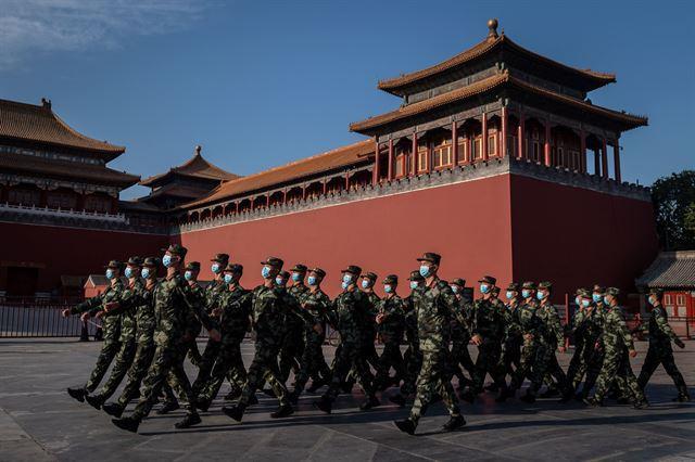 중국 수도 베이징의 자금성 앞에서 공안들이 행진하고 있다. 베이징=AFP 연합뉴스