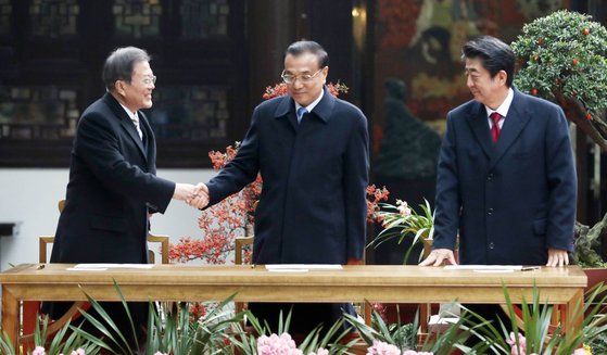 지난 2019년 12월 당시 문재인 대통령과 리커창 중국 총리, 아베 신조 일본 총리(왼쪽부터)가 중국 쓰촨성 청두 두보초당에서 열린 한·중·일 협력 20주년 기념 제막식에서 기념봉투에 서명한 뒤 인사하고 있다. 청와대사진기자단