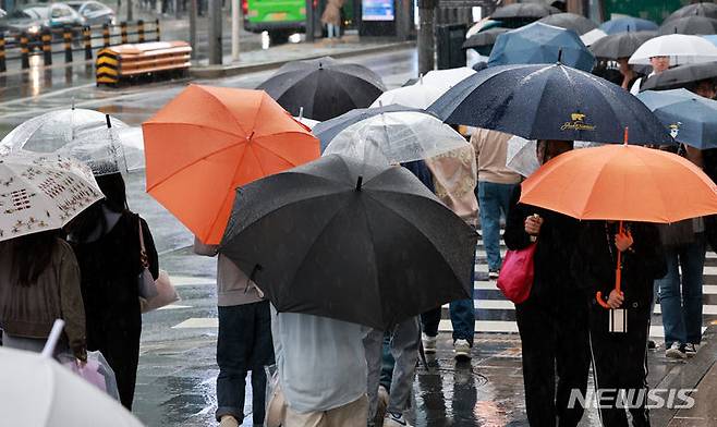 [서울=뉴시스] 이영환 기자 = 올여름은 평년보다 덥고, 비가 많이 올 확률이 높다는 기상청 전망이 나왔다. 다만 태풍은 예년과 비슷하거나 적게 올 가능성이 크다. 사진은 비가 내린 지난 15일 오후 서울 마포구 홍대입구역 인근에서 시민들이 우산을 쓰고 걸어가는 모습. 2024.05.15. 20hwan@newsis.com