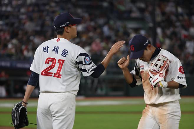 롯데 선발 투수 박세웅이 22일 KIA와 홈 경기에서 8회초를 실점 없이 마무리한 뒤 황성빈과 하이파이브하고 있다. 연합뉴스