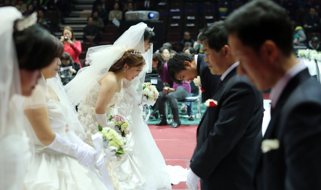 2013년 3월 5일 서울 올림픽공원 올림픽홀에서 열린 '아름다운 다문화가정 합동결혼식'에서 신랑, 신부가 인사하고 있다. 연합뉴스