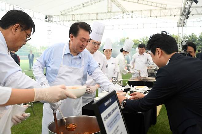 윤석열 대통령이 24일 서울 용산 대통령실 잔디마당에서 열린 출입기자단 초청 만찬 간담회에서 직접 조리한 김치찌개, 계란말이, 스테이크를 출입기자들에게 배식하고 있다. (사진=대통령실 제공) /사진=뉴시스화상