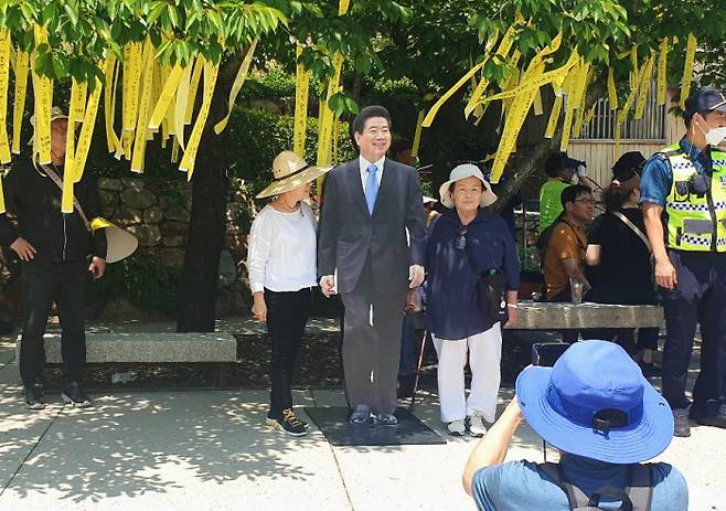 Mourners visit Bongha Village in Gimhae, South Gyeongsang Province, on the 15th anniversary of the death of former President Roh Moo-hyun, pose for a photo next to a panel of his photo.