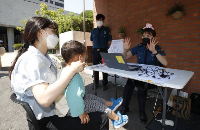 세계 실종 아동의 날을 하루 앞둔 24일 서울 종로구 서울경찰청어린이집에서 종로경찰서 소속 경찰이 어린이들의 얼굴을 촬영하고 있다. 연합뉴스