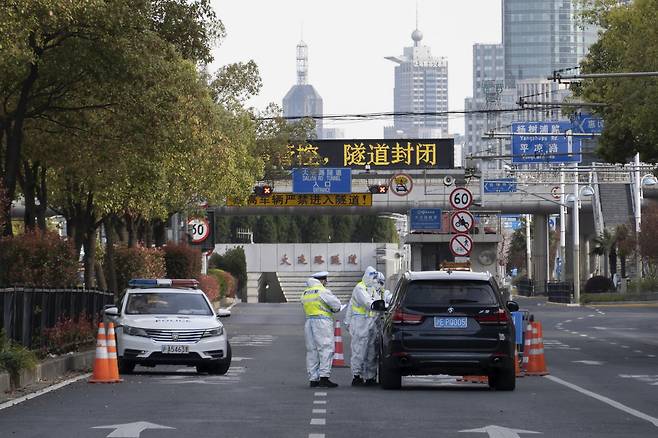2022년 3월28일 코로나19 발생으로 폐쇄된 중국 상하이의 지하 터널 앞. 경찰관들이 방호복을 입은 채 차량을 통제하고 있다. ⓒAP Photo