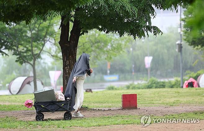 서울 뚝섬한강공원에서 한 시민이 비가 내리자 나들이 물품을 챙기고 있다. [연합뉴스 자료사진]
