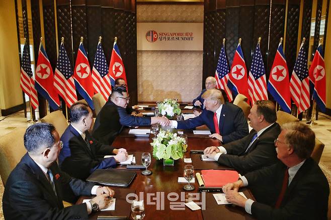 도널드 트럼프(오른쪽) 미국대통령과 김정은 북한 국무위원장이 2018년 6월 12일 싱가포르 센토사 섬 카펠라호텔에서 역사적인 첫 북미정상회담을 위해 만나 악수를 나누고 있다. (사진 AP=뉴시스)