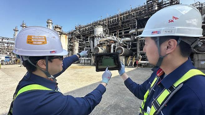 SK이노베이션 직원들이 증강현실(AR)을 활용해 비계 물량을 산정하고 있다.(사진=SK이노베이션.)