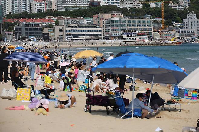 맑은 초여름 날씨를 보인 25일 오후 부산 해운대구 해운대해수욕장을 찾은 시민들이 더위를 식히고 있다. 연합뉴스