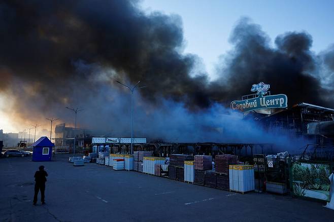 러시아 공격을 받은 우크라이나 하르키우 지역의 한 대형 상점이 25일 불에 타고 있다. 로이터 연합뉴스