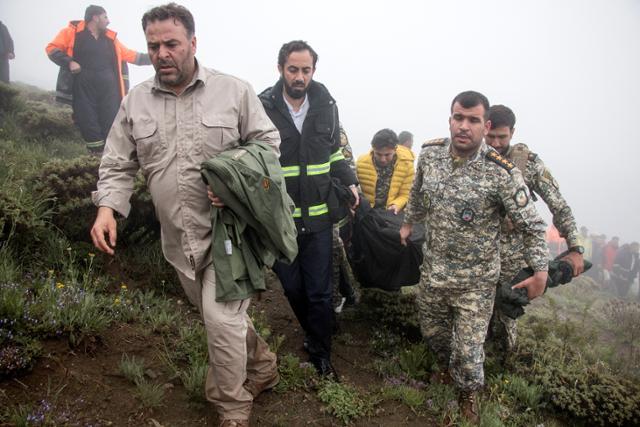 이란 구조대원들이 지난 20일 동아제르바이잔주 바르즈건 산악 지대에서 헬기 추락 사고로 숨진 에브라힘 라이시 이란 대통령의 시신을 수습하고 있다. 바르즈건=로이터 연합뉴스
