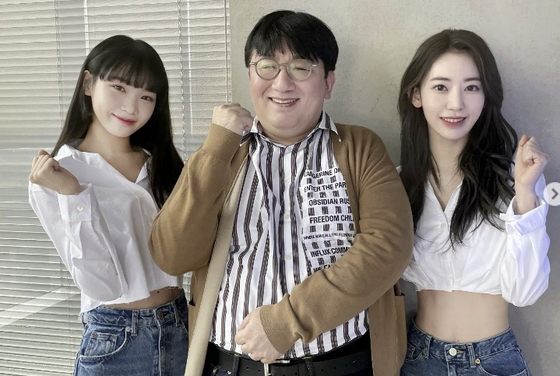 HYBE founder Bang Si-hyuk, in the middle, posing with Le Sserafim members Kim Chae-won and Sakura for a photo. [INSTAGRAM]