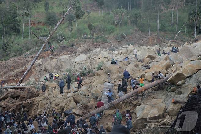 26일(현지시간) 파푸아뉴기니 엥가주에서 대규모 산사태가 발생한 뒤 주민들이 매몰자를 수색하고 있다. ⓒ 로이터=뉴스1 ⓒ News1 박형기 기자