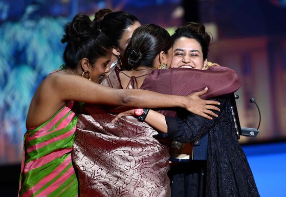 인도 감독 파얄 카파디아(맨오른쪽)와 배우들이 수상 무대에서 포옹을 나눴다. [AFP·로이터=연합뉴스, 사진 칸영화제]