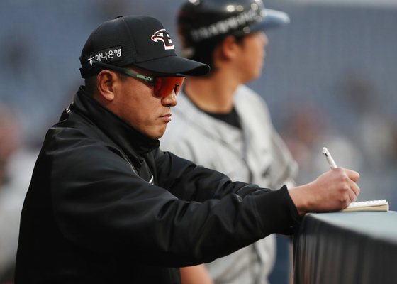 Hanwha Eagles manager Choi Won-ho scribbles in his notebook during a game against the NC Dinos at Changwon NC Park in Changwon, South Gyeongsang on April 17. [NEWS1]